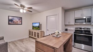 A modern kitchen with a wooden island, stainless steel appliances, and a ceiling fan. - Ruby 212: 1BD | Great LOCATION + Shared Amenities! (Pigeon Forge)