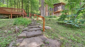 A wooden staircase leading to a cabin surrounded by a forest. - River's Edge Retreat (Sevierville)