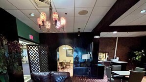A lobby with a patterned carpet, leather seating, a coffee table, and a chandelier. - Cozy Albany room with breakfast (Albany)