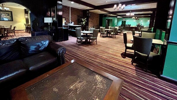 A hotel lobby with a leather sofa, a coffee table, and a dining area with tables and chairs. - Cozy Albany room with breakfast (Albany)
