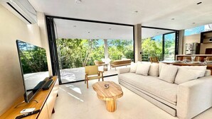 Un salon moderne avec un grand canapé, une table basse en bois et un téléviseur à écran plat.