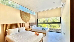 Een moderne slaapkamer met twee bedden, een groot raam en een plafondventilator.