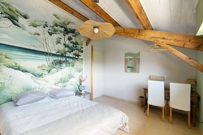 Quarto com cama, escrivaninha e cadeira.