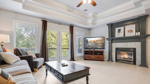 Una sala de estar con chimenea, televisor y sofá.
