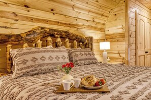 A cozy wooden room with a large bed, a wooden headboard, and a tray with breakfast items. - Ridge Hollow Retreat – Hot Tub, Fire Pit, Dogs (Gatlinburg)