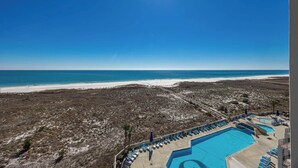 Ein Resort mit Pool, Strandblick und Liegebereich.