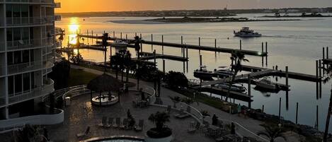 A resort with a swimming pool, a marina, and a sunset view.