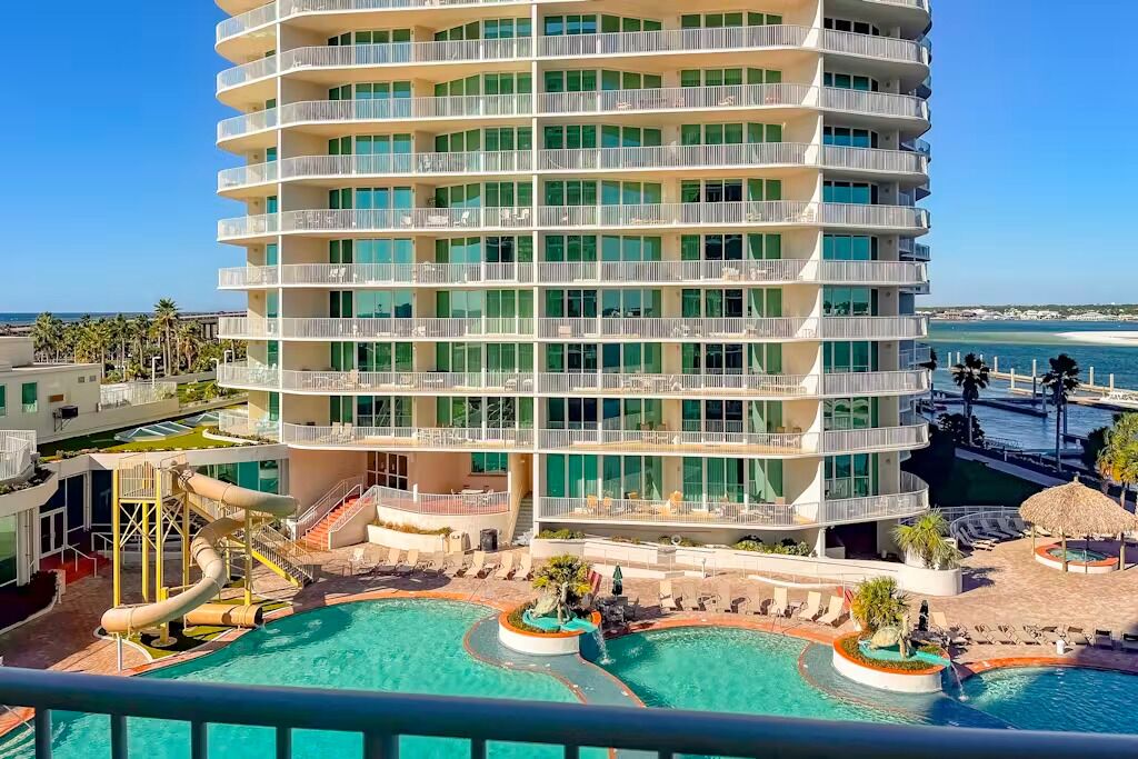 Un hôtel à plusieurs étages doté d’un espace piscine comprenant plusieurs piscines et un toboggan aquatique.