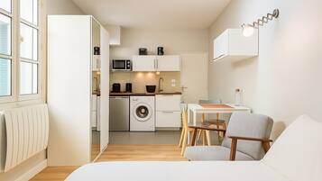 Un apartament modern i compacte amb cuina americana, zona de menjador i espai de saló.