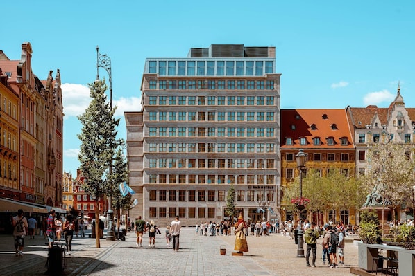 Un edificio moderno con fachada de vidrio, rodeado de arquitectura histórica.