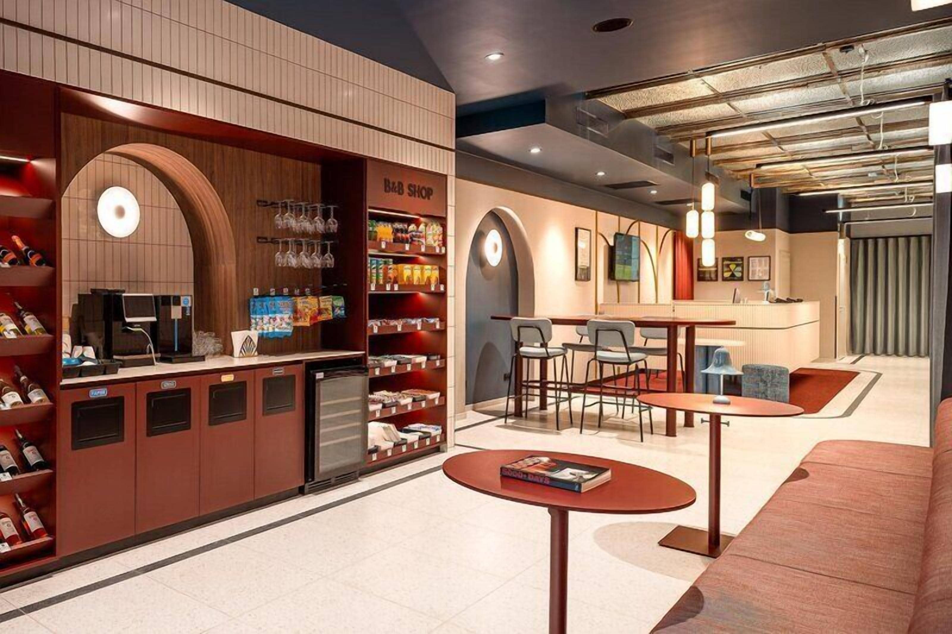 A bar area with a counter, seating, and shelves stocked with items.
