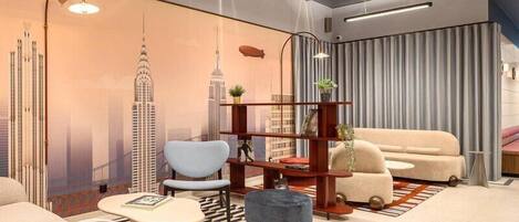 Una sala de estar moderna con un sofá, un sillón, un reposapiés y una estantería.