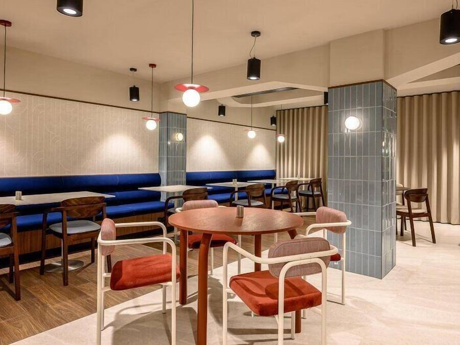 Un restaurante con mesas, sillas y cabinas, con una decoración azul y beige.