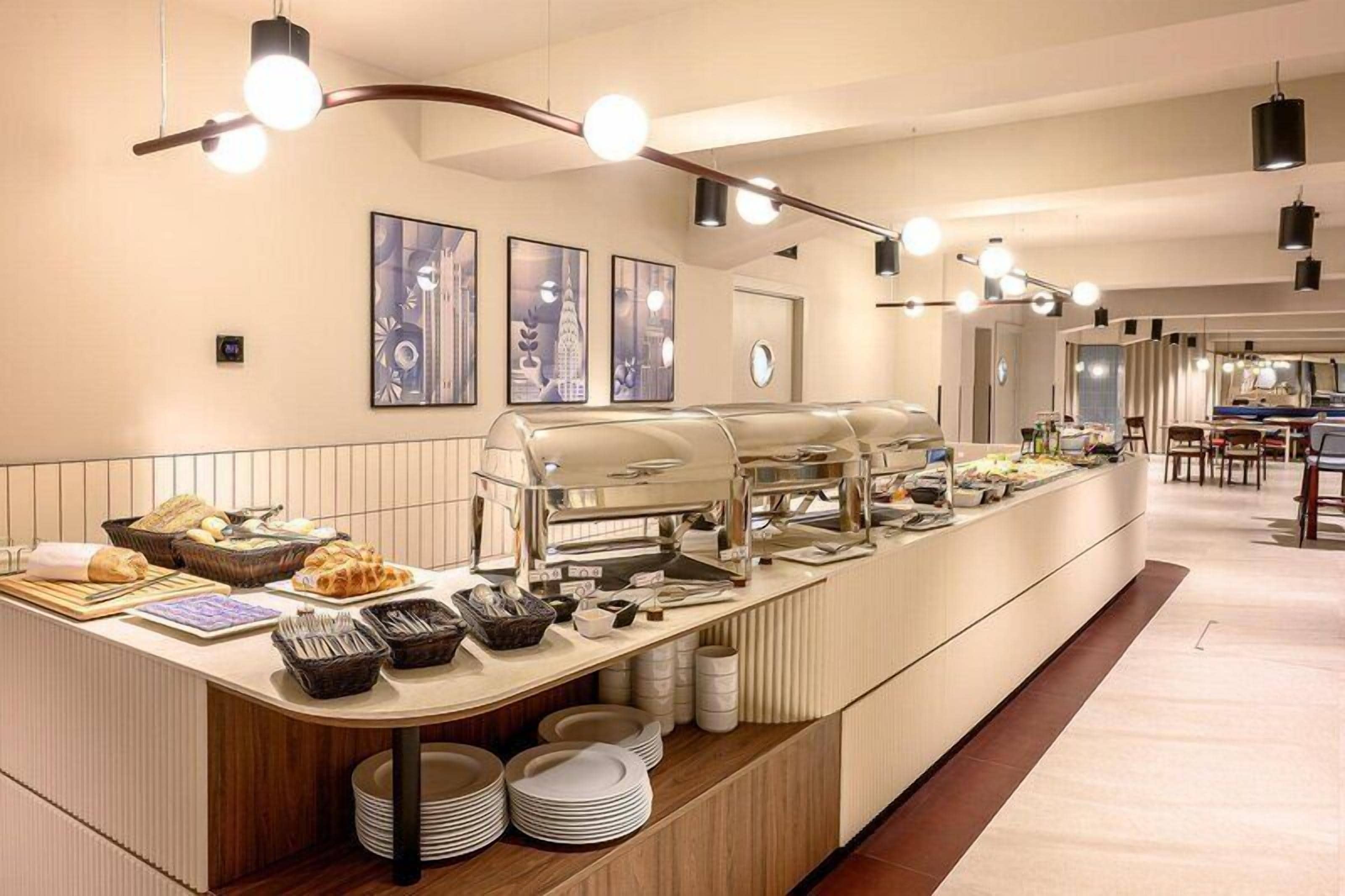 A buffet setup with a self-service station, a coffee machine, and a counter with food items.