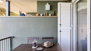 Un espace repas comprenant une table, des chaises, une verrière, une assiette en céramique et un objet décoratif accroché au mur.