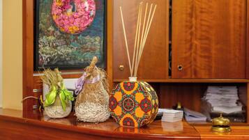 A wooden desk with a decorative vase, a small plant, and a stack of papers.