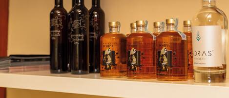 A shelf with various bottles of alcohol, including a prominent bottle labeled "DRAS Vodka."