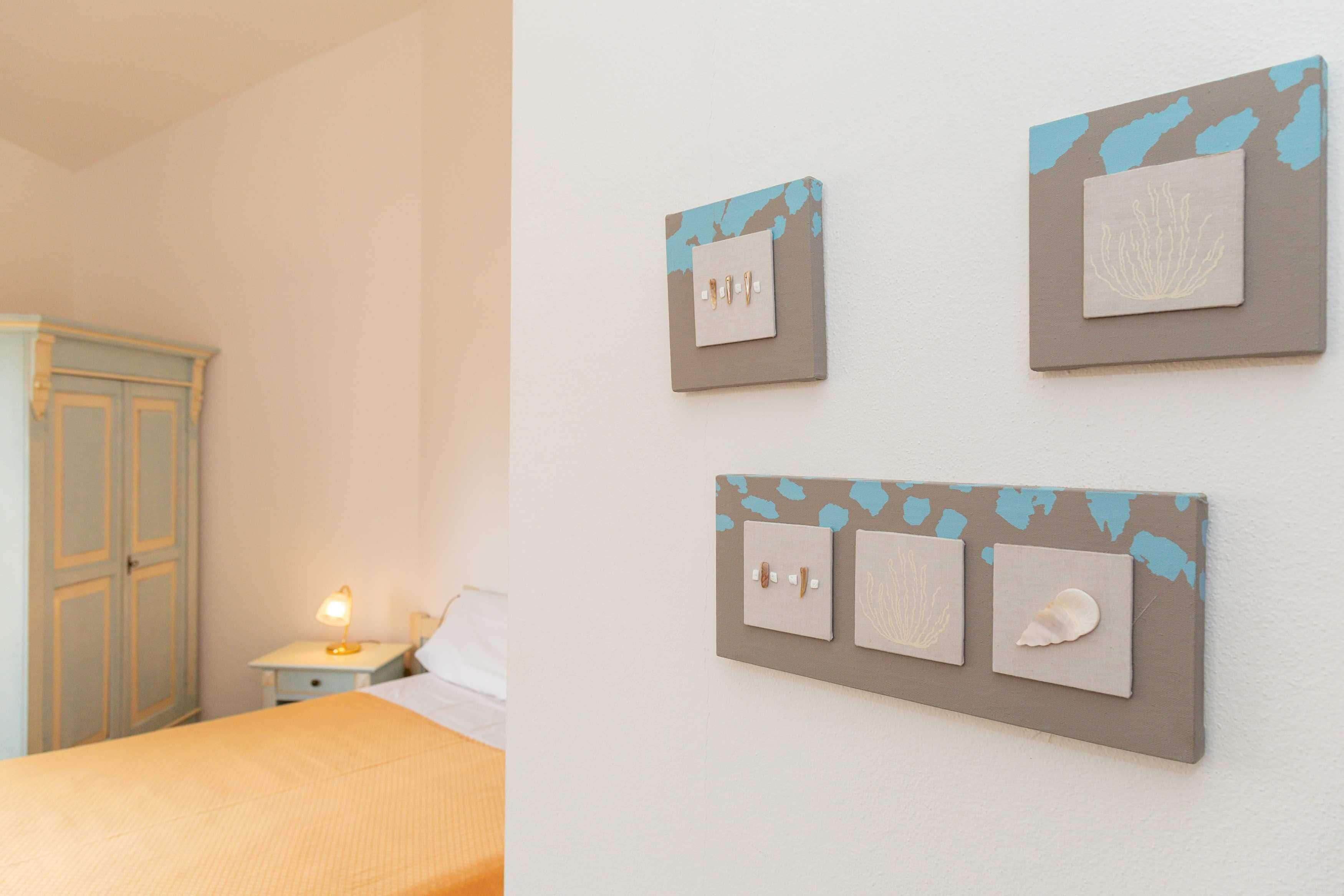 Une chambre à coucher comprenant un lit, une table de chevet et un panneau d’interrupteurs fixé au mur.