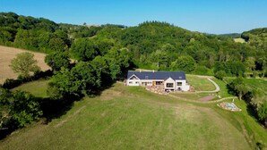 A large house with a dark roof, surrounded by lush green fields and trees. - Gîte Jardin: 50 m2 gîte for 2 to 4 people with terrace overlooking garden (Le Bô)