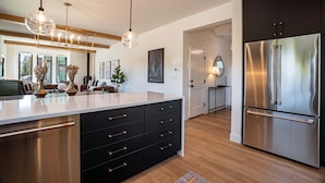 A modern kitchen with a large island, stainless steel appliances, and pendant lighting. - Walk to Town | Near Free Shuttle (Fraser)