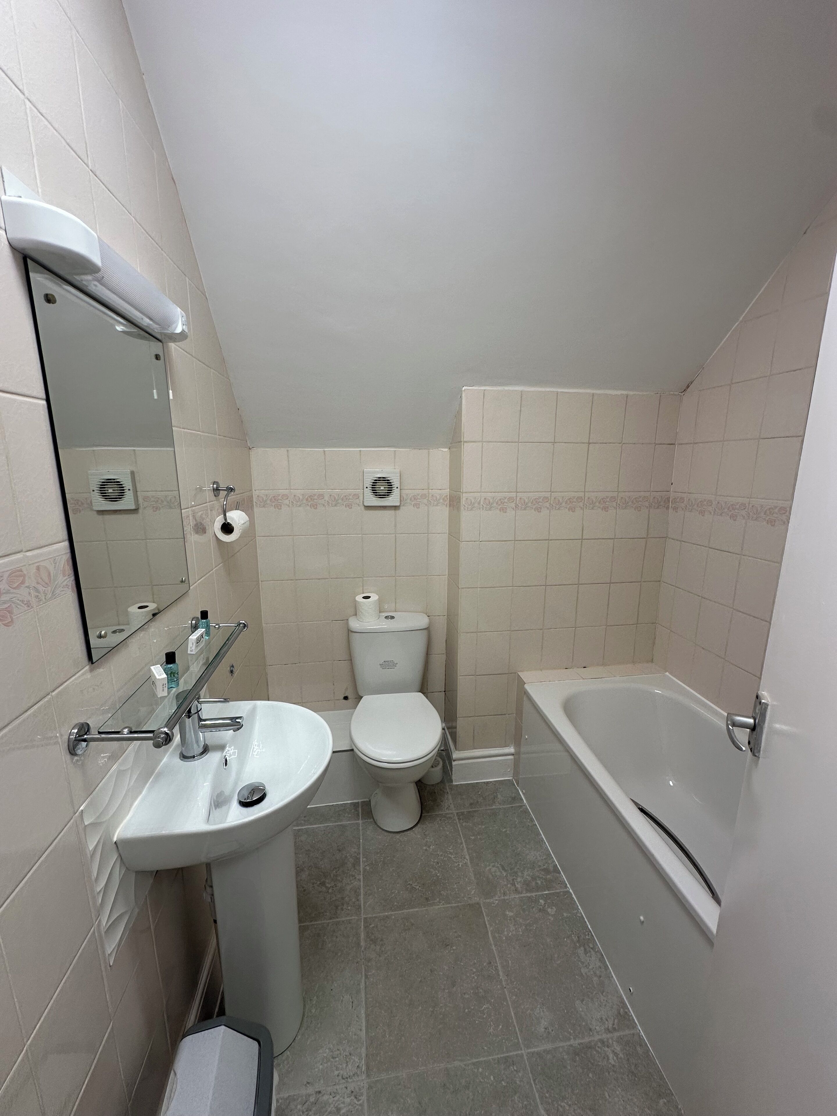 Un baño con lavamanos, inodoro y bañera.