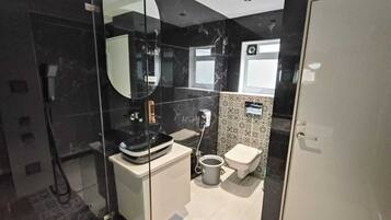 Quarto executivo | Banheiro | Chuveiro, toalhas de banho, sabonete, shampoo