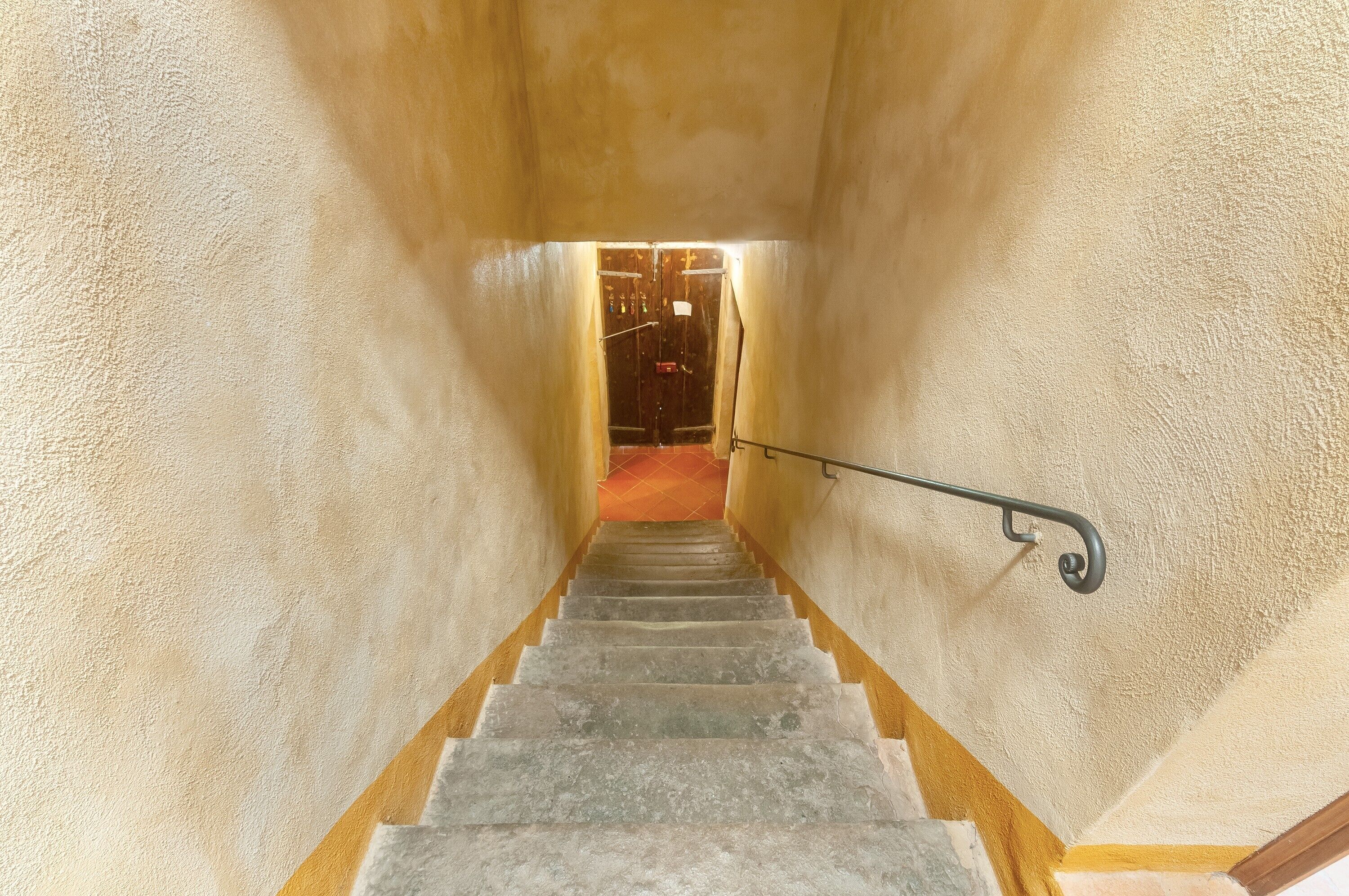 Eine Treppe mit Handlauf führt zu einer Tür oben.