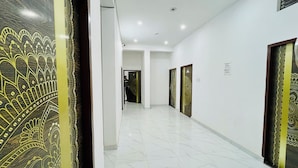 Un corridoio con porte decorate e pareti bianche.