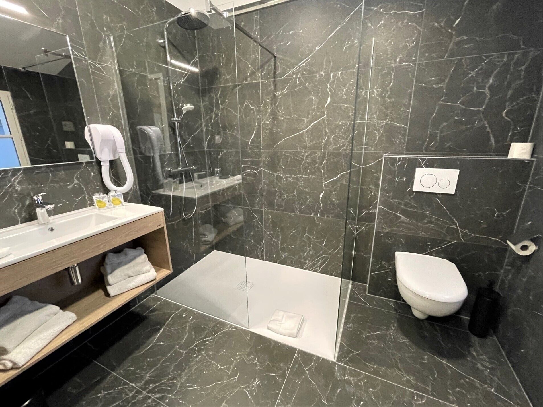 Un baño moderno con ducha, inodoro y lavamanos.