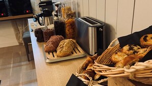 Ein Frühstücksbuffet mit Gebäck, einer Kaffeemaschine und einem Toaster.