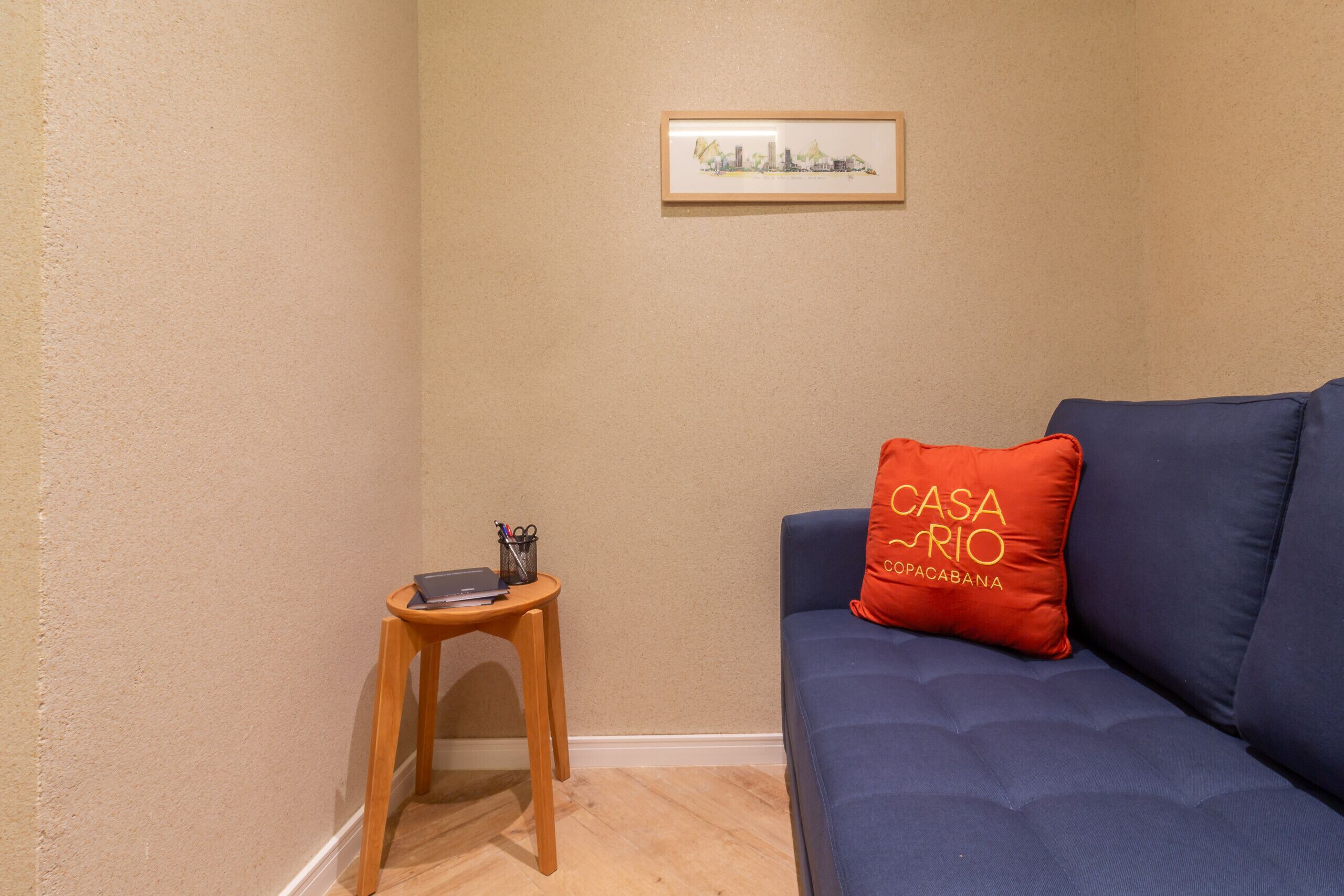 Ein Zimmer mit einem blauen Sofa, einem kleinen Holztisch und einem gerahmten Bild an der Wand.
