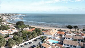 Zona residencial costera con casas, una playa y un puerto deportivo.