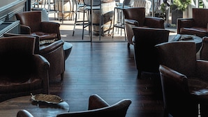 Een restaurant met uitzicht op de oceaan, met tafels en stoelen voor diners.