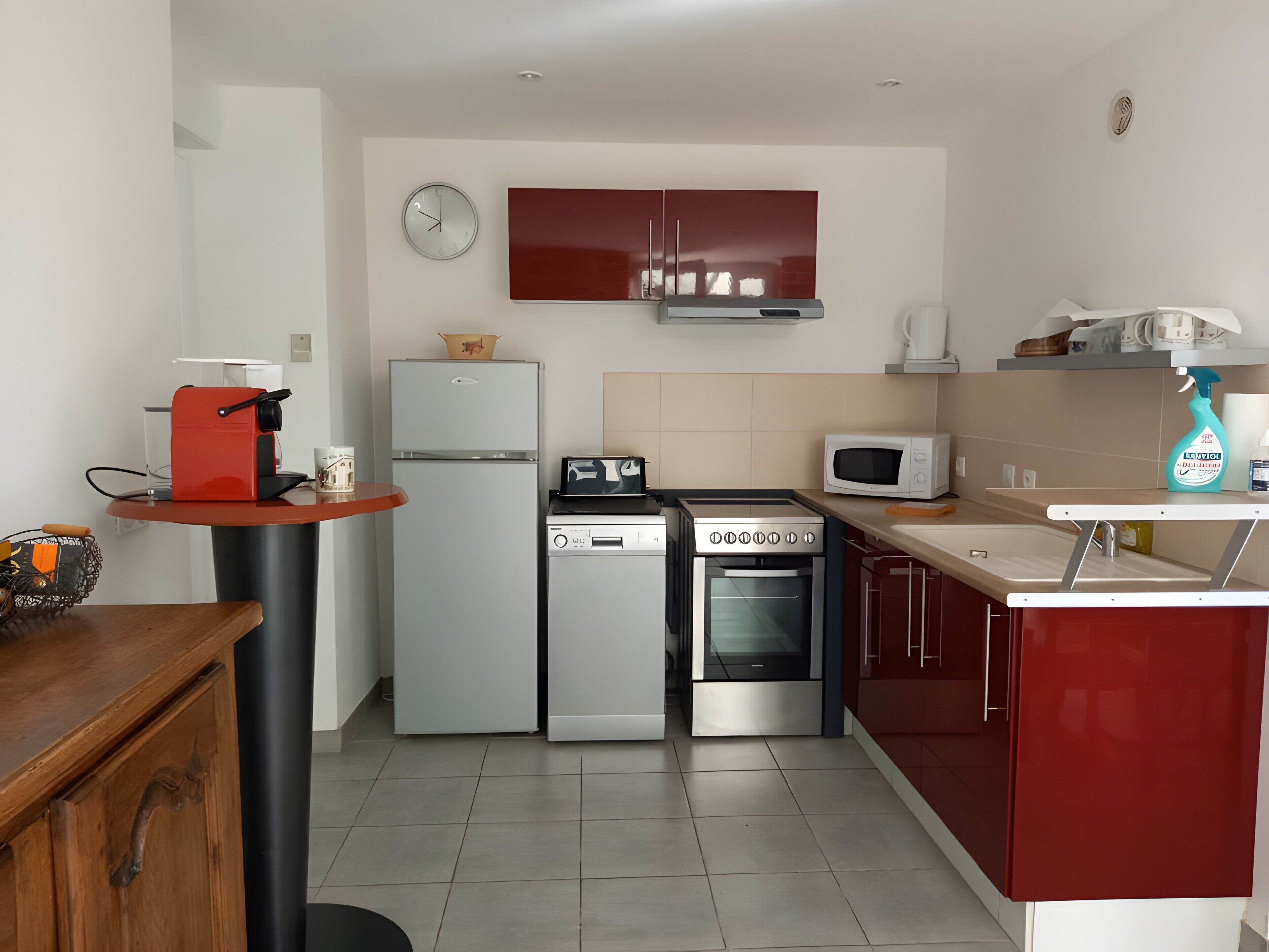 A compact kitchen with a refrigerator, microwave, stove, and dishwasher.