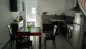 Una cucina compatta con angolo ristoro, un forno a microonde, una lavatrice e un piccolo lavandino.