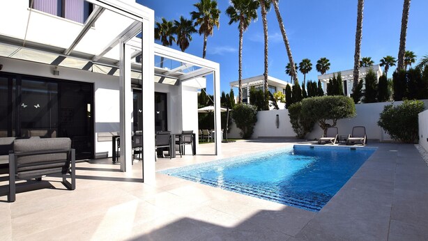 A modern outdoor pool area with a clear blue pool, lounge chairs, and palm trees. - Villa Levante, Modern Costa Blanca villa with pool and sunny terrace (San Fulgencio)