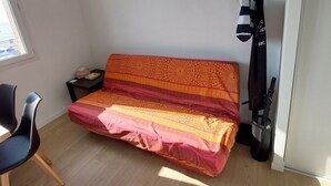 A small room with a sofa, a chair, a table, and a bicycle. - WEEKLY rental from SATURDAY to SATURDAY facing the sea QUEND PLAGE LES PINS 80 (quend plage les pins)