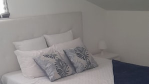 A bedroom with a bed, pillows, a nightstand, and a lamp. - Sea View 2 Bedrooms Terrace Villa (Funchal)
