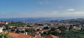 A coastal cityscape with terracotta-roofed buildings, a clear blue sky, and a distant view of the sea. - Sea View 2 Bedrooms Terrace Villa (Funchal)