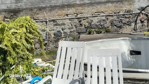 A two-story building with a balcony, a stone retaining wall, and a tall tree. - Sea View 2 Bedrooms Terrace Villa (Funchal)