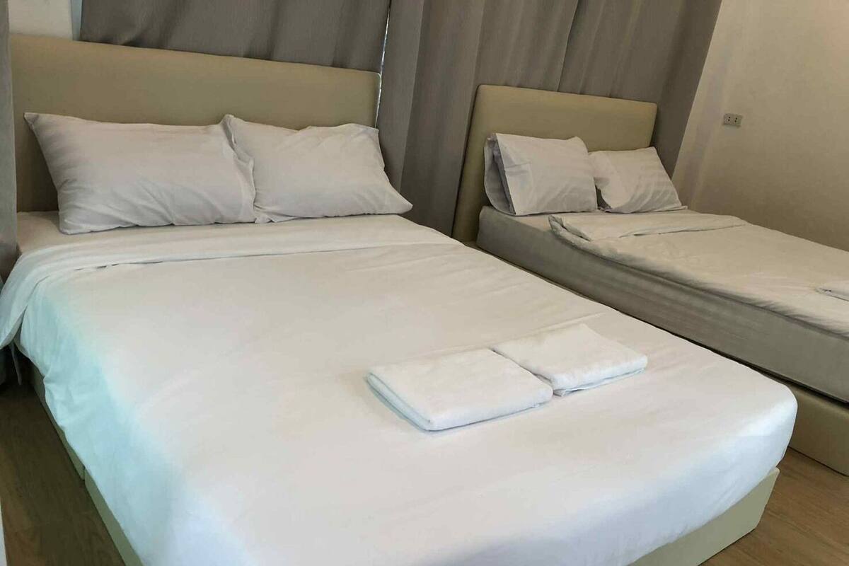 Ein Hotelzimmer mit zwei Betten, jeweils mit weißen Bettwäsche und Kissen.