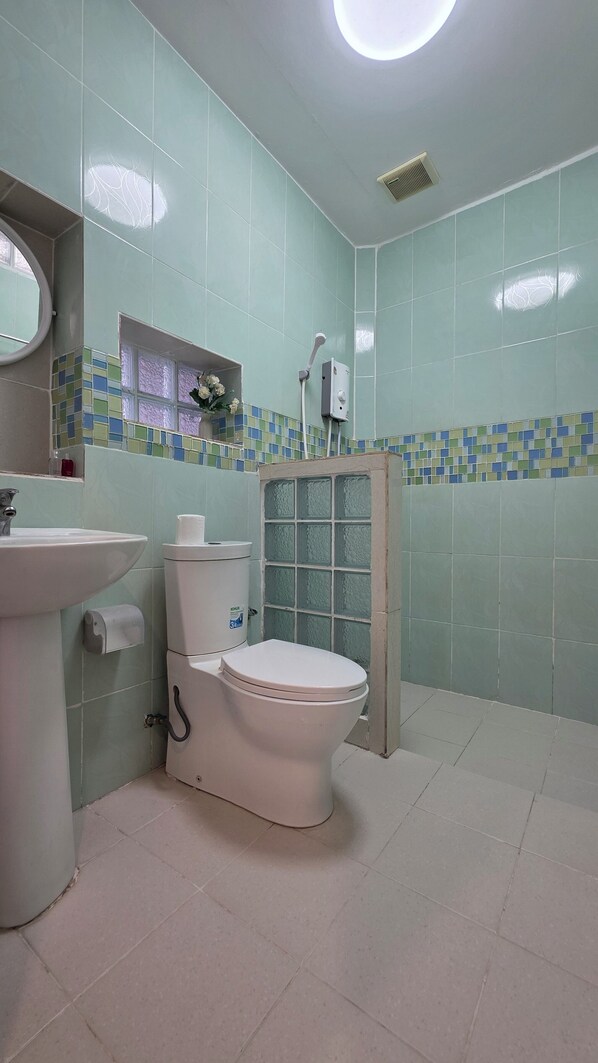 A bathroom with a toilet, sink, and shower.