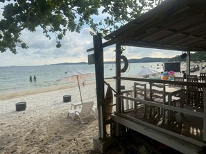 A beachside restaurant with outdoor seating, a lifebuoy, and a view of the sea. - Samed Big Cape Resort (Rayong)
