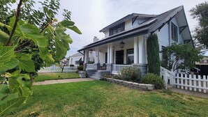 A two-story house with a front porch, stone steps, and a white picket fence. - Rosewood Landing- Hot Tub- Sauna  (Medford)