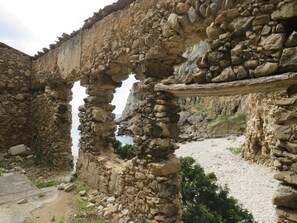 A stone structure with a collapsed archway, surrounded by rocky terrain and a clear sky. - Sesimbra 3 Bedrooms With Shared Pool (Sesimbra)