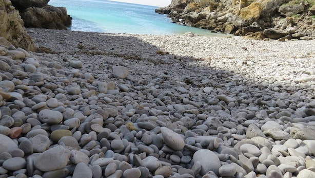 Ein felsiger Strand mit Blick auf das Meer und die Klippen.