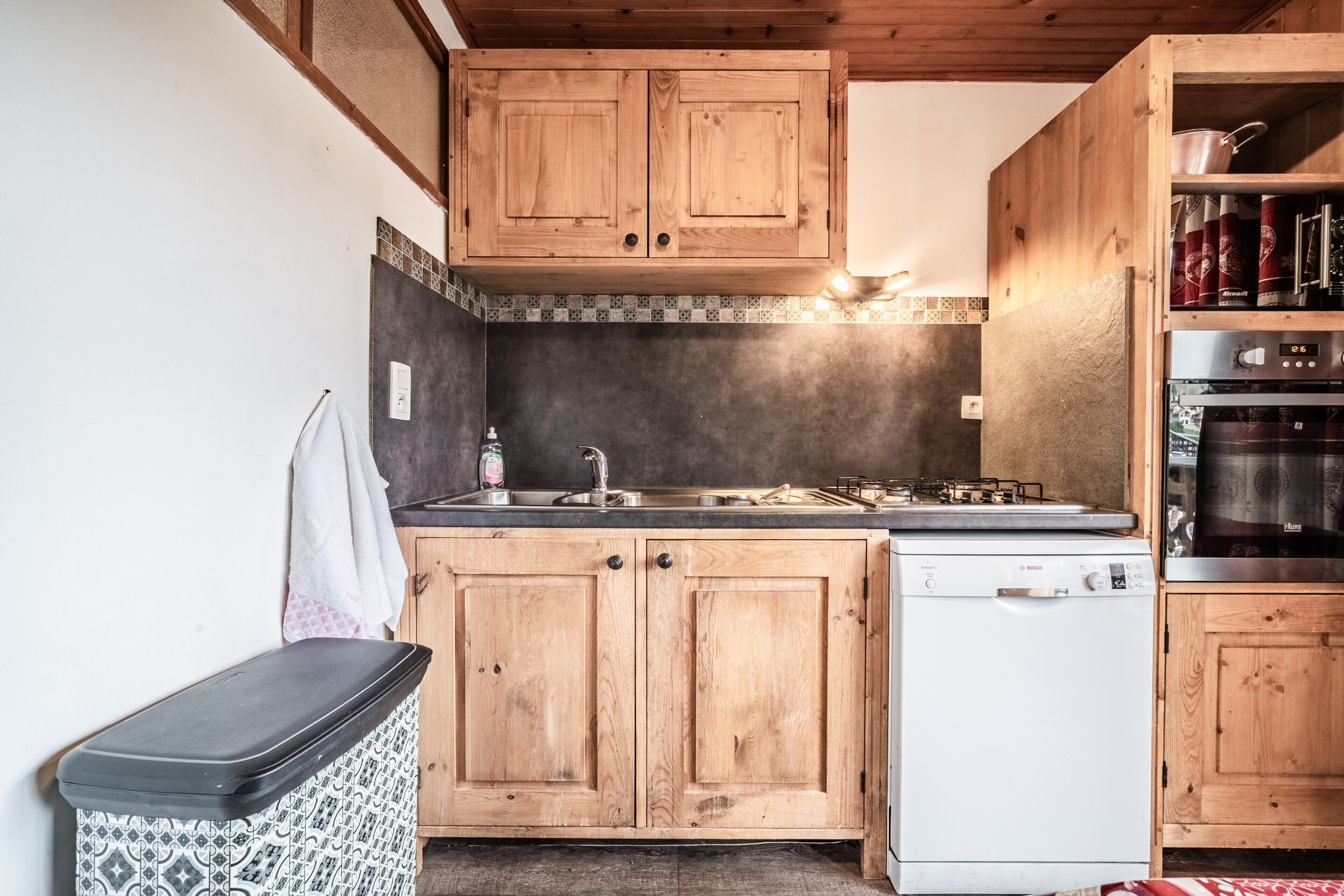 Una cocina con armarios de madera, un lavavajillas Bosch y una estufa.