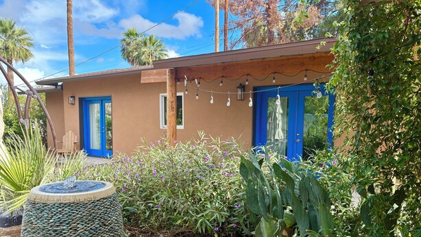 Una casa moderna con puerta azul y un pequeño porche.