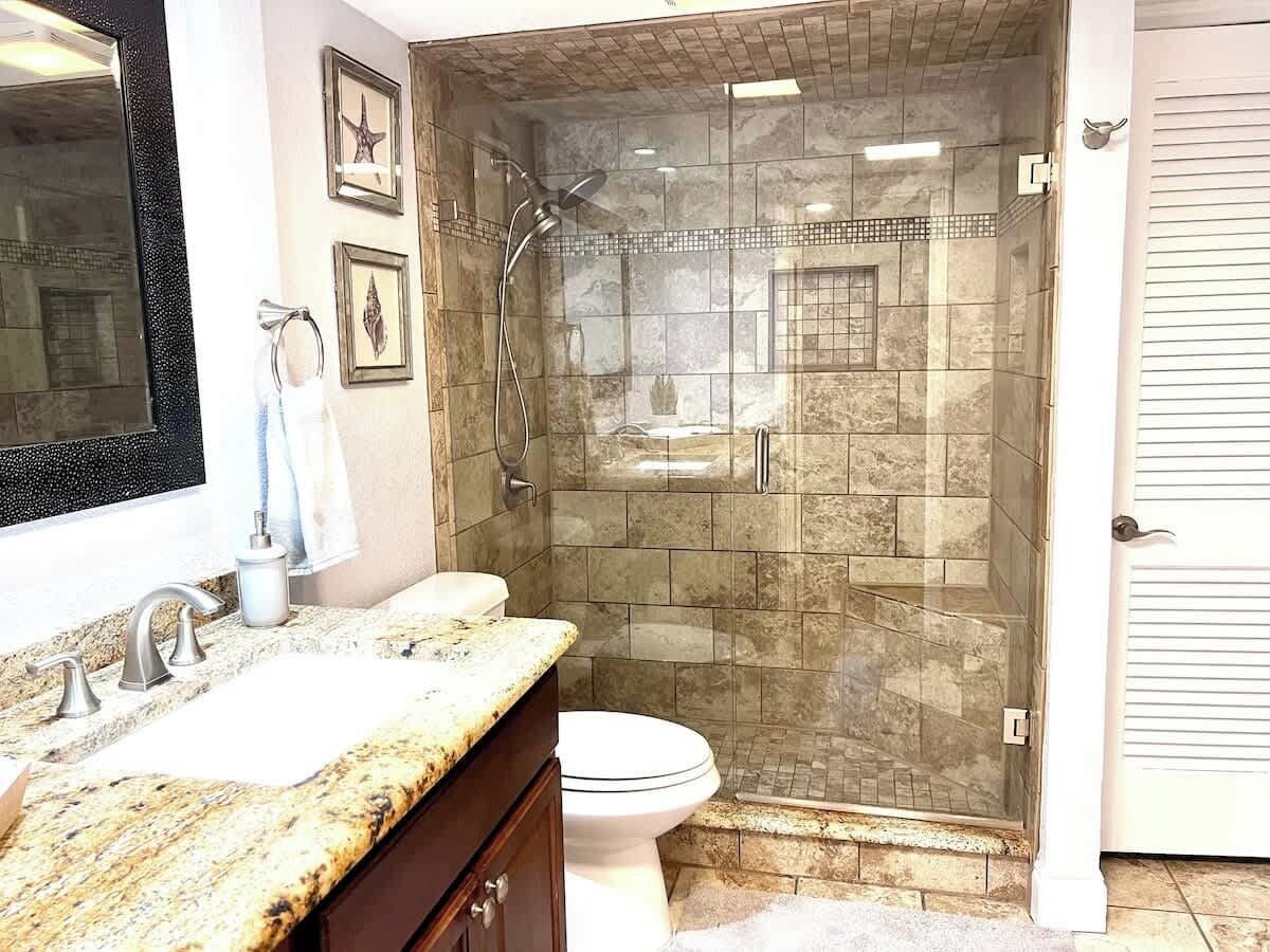 Une salle de bain avec douche, toilettes et lavabo.