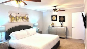 A bedroom with a large bed, two nightstands, a dresser, and two ceiling fans. - Spacious  2BD Condo  HWY360/30  Grand Prairie (GP22B) (Grand Prairie)